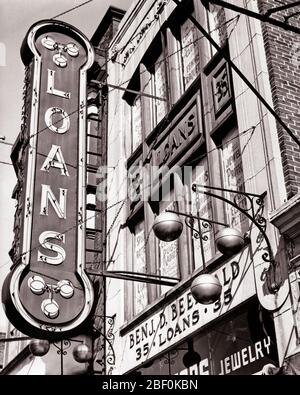 1940s PAWNBROKERS SHOP WITH NEON SIGN  FOR LOANS AND SYMBOL OF THREE GOLD SPHERES SUSPENDED FROM A BAR - b1855 HAR001 HARS AND EXTERIOR LOW ANGLE OCCUPATIONS REAL ESTATE CONCEPT CONCEPTUAL STRUCTURES STOREFRONT EDIFICE PAWNBROKERS SYMBOLIC CONCEPTS BLACK AND WHITE HAR001 LOANS OLD FASHIONED PAWN REPRESENTATION SUSPENDED Stock Photo