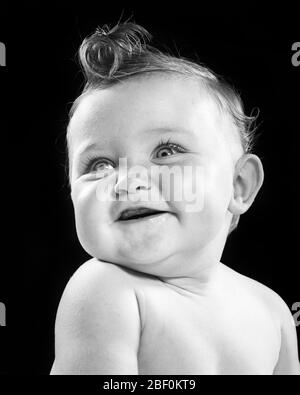 1950s CUTE BABY GIRL WITH  BIG CURL IN HAIR ON TOP OF HEAD - b8520 HAR001 HARS FEMALES STUDIO SHOT HEALTHINESS HOME LIFE COPY SPACE HALF-LENGTH CONFIDENCE EXPRESSIONS B&W HUMOROUS HAPPINESS CHEERFUL COMICAL IN OF ON SMILES COMEDY JOYFUL STYLISH CURL JUVENILES BABY GIRL BLACK AND WHITE CAUCASIAN ETHNICITY HAR001 OLD FASHIONED Stock Photo