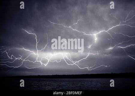 1970s MULTIPLE BOLTS OF LIGHTNING IN DARK STORMY SKY - f13335 HAR001 HARS ATMOSPHERE BLACK AND WHITE DISCHARGE ELECTROSTATIC HAR001 METEOROLOGY OLD FASHIONED PLASMA THUNDER Stock Photo