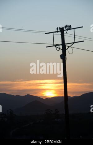sunset behind electricity pole over mountain range in little karoo, south africa Stock Photo