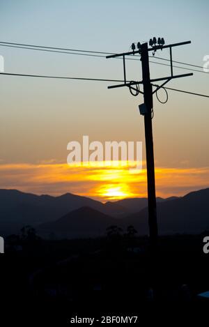 sunset behind electricity pole over mountain range in little karoo, south africa Stock Photo