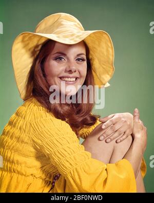 1960s 1970s SMILING YOUNG WOMAN WEARING YELLOW FLOPPY BRIM HAT AND BLOUSE LOOKING AT CAMERA - kg3428 HAR001 HARS HOME LIFE COPY SPACE HALF-LENGTH TEENAGE GIRL TRENDY CONFIDENCE EYE CONTACT BRUNETTE HAPPINESS HEAD AND SHOULDERS STYLES AND BEADS BLOUSE FLOWER CHILD SMILES FAD STYLISH TEENAGED FLOPPY FASHIONS JUVENILES PEOPLE ADULTS YOUNG ADULT WOMAN BRIM CAUCASIAN ETHNICITY HAR001 OLD FASHIONED Stock Photo
