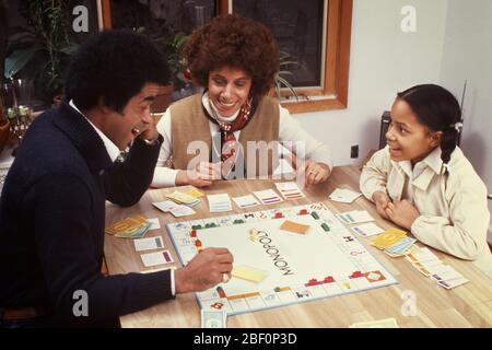 1970s 1980s ANIMATED SMILING COMPETING AFRICAN-AMERICAN FAMILY MOTHER FATHER DAUGHTER PLAYING MONOPOLY BOARD GAME TOGETHER - kj8848 PHT001 HARS 3 DAD MOM CLOTHING INDOORS FACES NOSTALGIC PAIR SUBURBAN URBAN COLOR MOTHERS EXPRESSION OLD TIME NOSTALGIA OLD FASHION 1 SILLY JUVENILE FACIAL STYLE COMMUNICATION COMIC COMPETITION STRONG PLEASED FAMILIES JOY LIFESTYLE FEMALES MARRIED SPOUSE HUSBANDS HOME LIFE COPY SPACE FRIENDSHIP HALF-LENGTH LADIES DAUGHTERS PERSONS AFRO CARING MALES RISK ENTERTAINMENT EXPRESSIONS FATHERS PARTNER GOALS HUMOROUS HAPPINESS CHEERFUL HIGH ANGLE LEISURE AFRICAN-AMERICANS Stock Photo