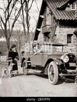 1920s WELL-TO-DO WOMAN SITTING IN PACKARD AUTOMOBILE OPENING CAR DOOR TALKING TO FRIEND WEARING FUR TRIMMED COAT WALKING HER DOG - m589 HAR001 HARS WEALTHY RICH LIFESTYLE FEMALES HOME LIFE LUXURY COPY SPACE FRIENDSHIP FULL-LENGTH LADIES PERSONS AUTOMOBILE SIBLINGS SISTERS TRANSPORTATION B&W MAMMALS HEAD AND SHOULDERS STYLES AUTOS CANINES SIBLING TRIMMED UPSCALE POOCH AFFLUENT AUTOMOBILES FRIENDLY STYLISH VEHICLES CANINE COOPERATION FASHIONS MAMMAL MID-ADULT MID-ADULT WOMAN PACKARD WELL-TO-DO BLACK AND WHITE CAUCASIAN ETHNICITY HAR001 OLD FASHIONED Stock Photo