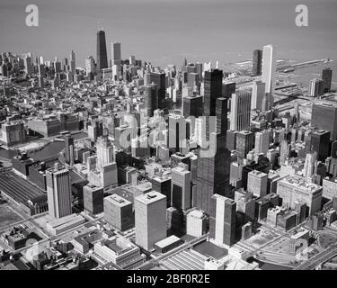 1970s AERIAL SKYLINE LOOKING NORTHEAST OVER THE  LOOP NOTABLE ARE JOHN HANCOCK SEARS AND STANDARD OIL BUILDINGS CHICAGO IL USA - r24153 KRU001 HARS EDIFICE NOTABLE ILLINOIS SEARS SEARS TOWER AERIAL VIEW BLACK AND WHITE FRESH WATER IL JOHN HANCOCK LAKE MICHIGAN MIDWEST MIDWESTERN OLD FASHIONED SKYSCRAPERS Stock Photo
