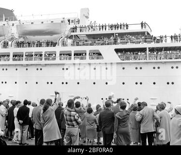 1960s 1970s CRUISE SHIP LEAVING PORT PASSENGERS WAVING BON VOYAGE TO FRIENDS AND FAMILY LEFT ON THE DOCK - s16712 HAR001 HARS PORT HAPPINESS BON ADVENTURE LEISURE TRIP AND GETAWAY EXCITEMENT LOW ANGLE VOYAGE HOLIDAYS JOURNEY UPSCALE BON VOYAGE AFFLUENT ESCAPE LEFT VACATIONS WELL-TO-DO BLACK AND WHITE HAR001 OLD FASHIONED VESSEL Stock Photo