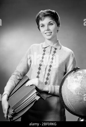 1950s 1960s  BRUNETTE WOMAN TEACHER CARRYING CLASS MATERIALS  BOOKS NOTEBOOKS SMILING STANDING BY GLOBE WEARING SWEATER - s8309 HAR001 HARS YOUNG ADULT INFORMATION PLEASED JOY LIFESTYLE SATISFACTION FEMALES JOBS STUDIO SHOT HEALTHINESS COPY SPACE HALF-LENGTH LADIES PERSONS PROFESSION CONFIDENCE EXPRESSIONS B&W BRUNETTE SKILL OCCUPATION HAPPINESS SKILLS SATISFIED CHEERFUL CAREERS INSTRUCTOR KNOWLEDGE LEADERSHIP NOTEBOOKS PRIDE OCCUPATIONS SMILES EDUCATOR JOYFUL MATERIALS STYLISH EDUCATING EDUCATORS INSTRUCTORS SCHOOL TEACHES YOUNG ADULT WOMAN BLACK AND WHITE CAUCASIAN ETHNICITY HAR001 Stock Photo