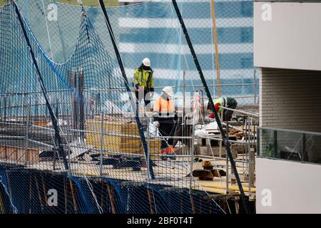 Photograph of a group of workers working in construction with masks during the covid-19 pandemic Stock Photo