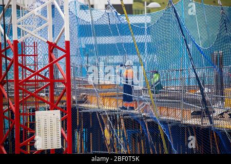 Image of two construction workers wearing masks during the covid-19 pandemic Stock Photo