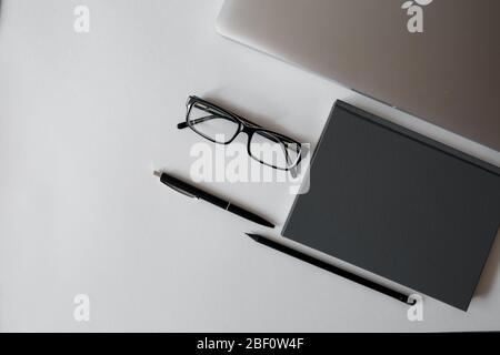 Desk White office desk table with a lot of things tablet, laptop ,smartphone and coffee cup notepad . Top view with copy space,flat lay. Stock Photo