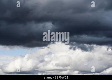 Dramatic cloudy sky, dark thundercloud over light cumulus clouds, Switzerland Stock Photo