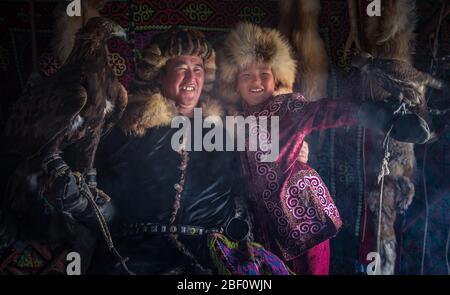 Mongolian eagle hunters, father and son with trained eagles in yurt, Bajan-Oelgii province, Mongolia Stock Photo
