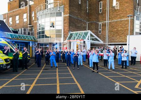 Dorchester, Dorset, UK.  16th April 2020.  Frontline staff including doctors, nurses, police and fire and rescue staff clap for carers, key workers and NHS staff outside the entrance to the A&E department at Dorset County Hospital at Dorchester in Dorset during the coronavirus pandemic lockdown.  Picture Credit: Graham Hunt/Alamy Live News Stock Photo