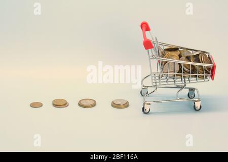 Shopping cart with Russian money. Metal coins and a souvenir shopping basket. Stock Photo