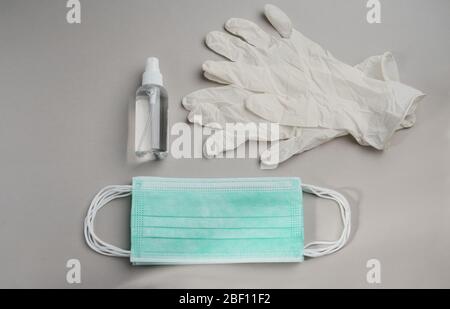Top view of Epidemic Protective kit, Masks pile, gloves and alcohol hand sanitizer bottle on gray background Stock Photo