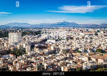 Cityscape of Alicante by day with the peaks of Serra del Maigmó natural park on the horizon seen from the Santa Barbara castle. Stock Photo