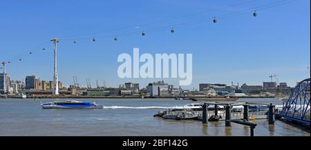 Panoramic view thames clipper catamaran river bus under Emirates Air Line cable car links Greenwich Peninsula to Royal Victoria Dock London England UK Stock Photo