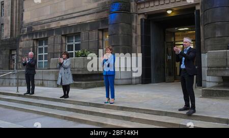 (left to right) Malcolm Wright Director General Chief Executive NHS Scotland, Health Secretary Jeane Freeman, First Minister Nicola Sturgeon and Dr Gregor Smith Scotland's interim chief medical officer applaud outside St Andrew's House, the headquarters building of the Scottish Government in Edinburgh, to salute local heroes during Thursday's nationwide Clap for Carers initiative to recognise and support NHS workers and carers fighting the coronavirus pandemic. Stock Photo