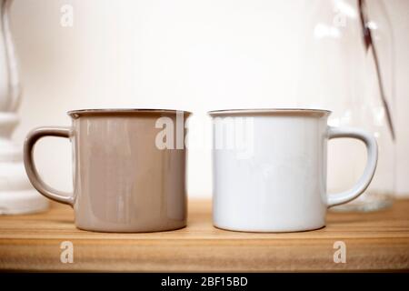 Brown and white coffee mugs on wooden table, cozy cute design in lovely home background Stock Photo