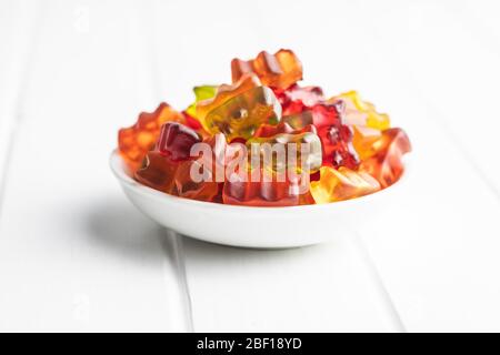 Gummy bears, jelly candy. Colorful bonbons in bowl on white table. Stock Photo