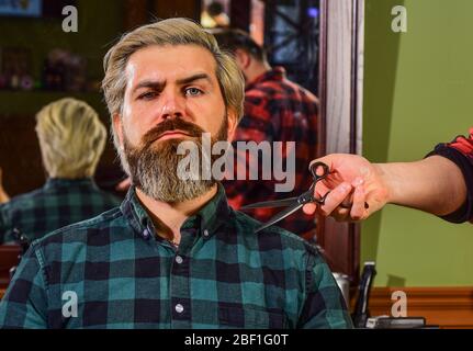 Making hair look magical. hairdresser cutting hair of male client. Hairstylist serving client at barber shop. Personal stylist barber. retro and vintage. Designing haircut. barber tools in barbershop. Stock Photo