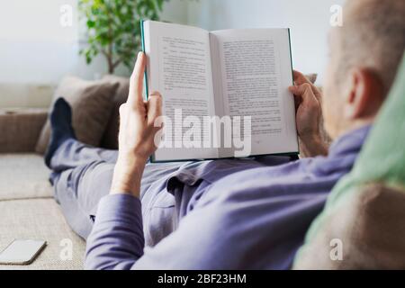 Man reading book at home Stock Photo
