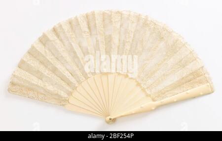 Pleated fan. Pleated fan with needle lace leaf showing royal procession, lined with net. Ivory sticks. Guards have raised bumps in imitation of bamboo. Stock Photo