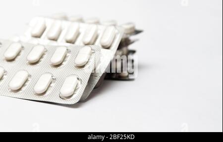 Heap of white medical pills in plastic package. Concept of healthcare and medicine. Stock Photo