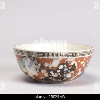 Bowl. Circular with rounded sides. Outside mottled in dark brown, blue and white against lighter brown ground, suggesting composite stone. White band about top with black cross-hatching. Ring foot ground down. Stock Photo