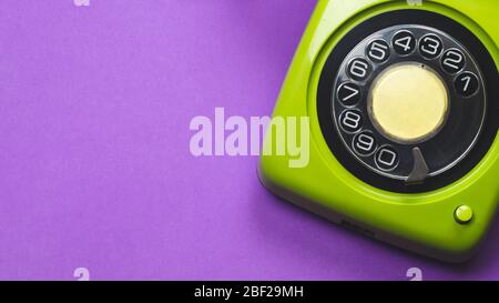 Rotary phone. classic green telephone with round dial. isolated on purple background. old communication technology. copy space Stock Photo