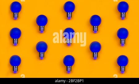 Blue light bulbs on a yellow background. pattern of colored bulbs Stock Photo