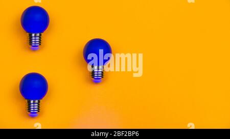 Blue light bulbs on a yellow background. several lightbulbs with copy space Stock Photo