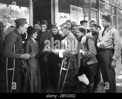 American Red Cross Worker distributing Cigarettes to wounded American Soldiers at Rest Station, Vittel, France, Lewis Wickes Hine, American National Red Cross Photograph Collection Stock Photo