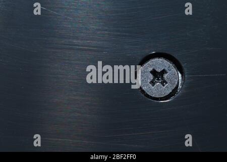 Screw in black plastic plate close up Stock Photo