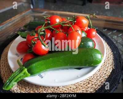 Red tomatoes and fresh green courgettes (zucchine) , fresh vegetables and healthy food Stock Photo