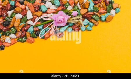 Festive decoration. candy pebbles. sweets in the form of colored stones on a yellow background. copy space Stock Photo