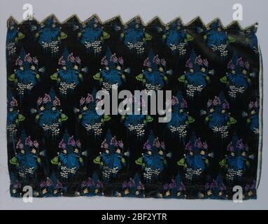 Fragment. Fragment of a dress silk with an allover design of floral sprays and a lace pattern in blue, green, purple and white. On a black ground. Stock Photo