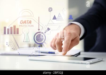 Businessman with tablet computer and hologram projection of data protection service in office, closeup Stock Photo