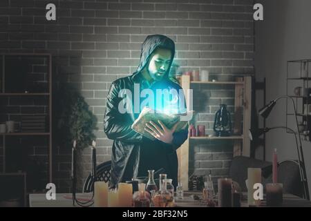 Male alchemist with spell book in laboratory Stock Photo