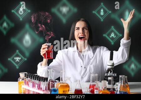 Crazy female alchemist making elixir in laboratory Stock Photo