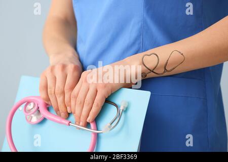 Female doctor with tattoo of stethoscope on arm, closeup Stock Photo - Alamy