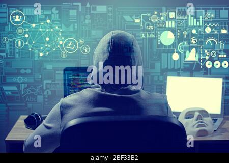 Professional hacker using computer in dark room Stock Photo