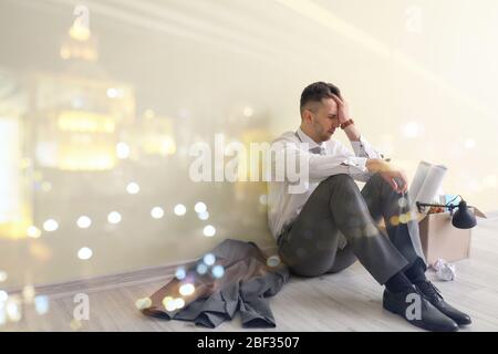 Double exposure of sad fired man sitting near color wall and illuminated city at night Stock Photo