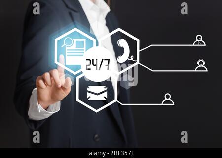 Technical support agent with digital icons on dark background, closeup Stock Photo