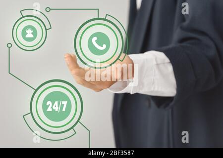 Technical support agent with digital icons on grey background, closeup Stock Photo