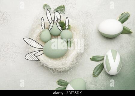 Beautiful Easter eggs with drawn bunny ears on color background Stock Photo