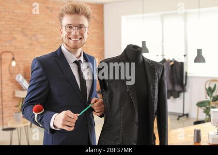 Young tailor working with mannequin in atelier Stock Photo