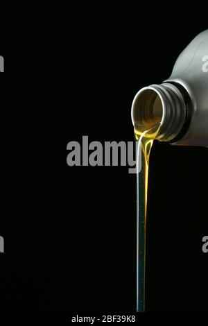 Pouring car oil on dark background Stock Photo