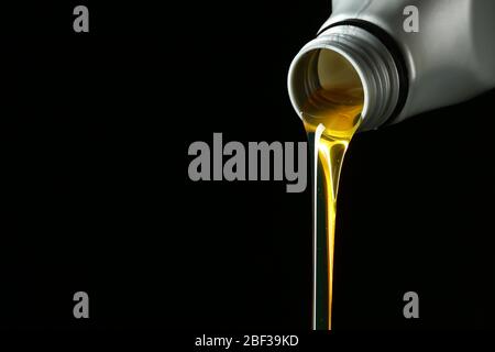 Pouring car oil on dark background Stock Photo