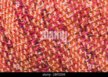 Fabric macro texture. knitted textile close up. woven background. woolen material. weaving orange and red threads Stock Photo